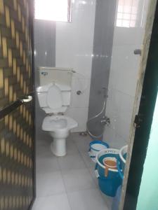 a small bathroom with a toilet and a shower at Ashirwad Cottage in Matheran