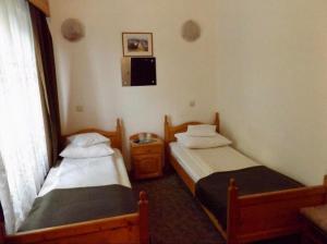 2 łóżka pojedyncze w pokoju z oknem w obiekcie Tulipán Panzió w mieście Sfântu Gheorghe