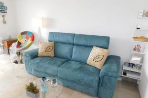 a blue couch in a living room with a table at Charming T2 "Sainte Marguerite" with air conditioning sea view and parking in Antibes