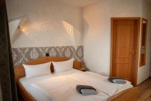 ein Schlafzimmer mit einem Bett mit zwei Hüten darauf in der Unterkunft Terrassenhotel Seepromenade in Edersee