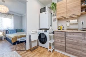 a small kitchen with a washing machine and a bed at Prusu 17a in Rīga