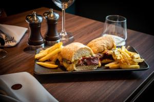 a plate with a sandwich and french fries on a table at The Landing Hotel in Westerham