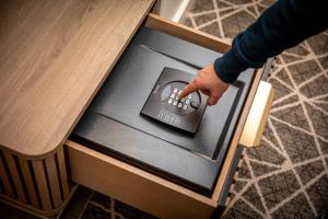 a hand reaching into a drawer with a remote control at The Landing Hotel in Westerham