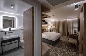 ein Hotelzimmer mit einem Bett und einem Bad in der Unterkunft The Landing Hotel in Westerham