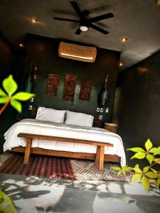 um quarto com uma cama e uma ventoinha de tecto em Casa Vive Bacalar em Bacalar