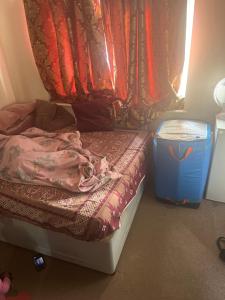a bedroom with a bed and a blue trash can at The Croydon Road house in Elmers End