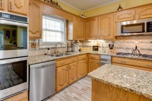 a kitchen with wooden cabinets and marble counter tops at Douglasville Lake Home with Private Pool and Gazebo! in Douglasville