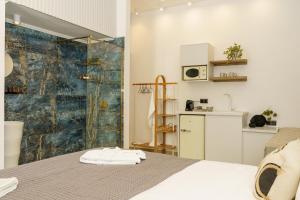 a bedroom with a bed and a shower and a kitchen at La Vie Hydra Luxury Suites in Hydra