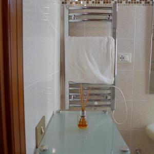 een badkamer met een wastafel met een spiegel en een handdoek bij Casa in Piazza in Vasto