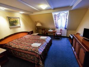 a hotel room with a bed and a table and a window at Offi Haz Hotel in Eger