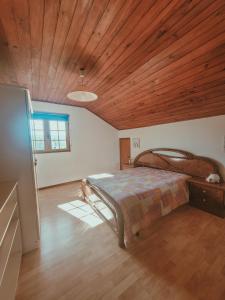 um quarto com uma cama e um tecto de madeira em Casa do Xisto em Ponte de Lima