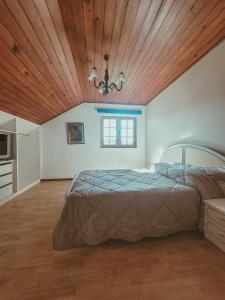um quarto com uma cama e um tecto de madeira em Casa do Xisto em Ponte de Lima
