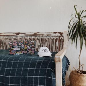 a baseball cap sitting on a bed next to a plant at No Worries Pipa in Pipa +76 photos