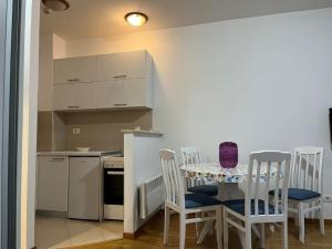 cocina con mesa y sillas y cocina con encimera en Lovely apartment with the parking place, en Podgorica