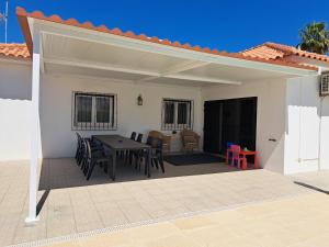 a patio with a table and chairs under a roof at Villa Claramar in Albufeira