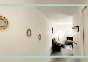 a living room with a chair and a mirror on the wall at Spacieux T3 au pied des Thermes in Néris-les-Bains