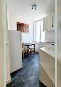 uma cozinha com uma mesa e uma sala de jantar em Spacieux T3 au pied des Thermes em Néris-les-Bains
