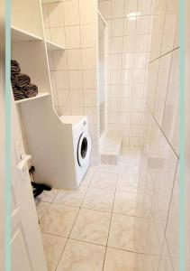 La salle de bains est pourvue d'une douche et de toilettes. dans l'établissement Spacieux T3 au pied des Thermes, à Néris-les-Bains