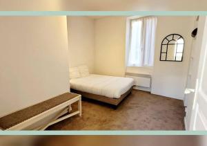 een kleine slaapkamer met een bed en een raam bij Spacieux T3 au pied des Thermes in Néris-les-Bains