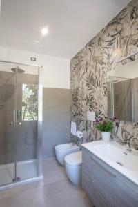 a bathroom with a shower and a toilet and a sink at Tarsis Guest House in Baunei +9 photos