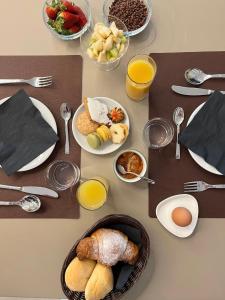 a table topped with plates of breakfast foods and eggs at Tarsis Guest House in Baunei