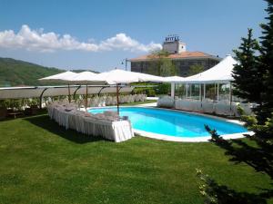 a swimming pool with white umbrellas and a building at La Fonte dell'Astore in Castelpetroso