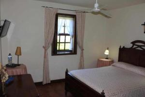 um quarto com uma cama e uma janela em Quinta do Pomarinho em Arouca