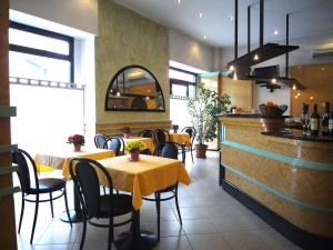 a restaurant with tables and chairs and a bar at Hotel Siena in Milan