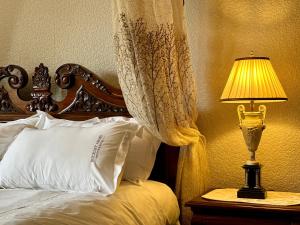 um quarto com uma cama com um candeeiro sobre uma mesa em The Buckley Arms em Dinas Mawddwy
