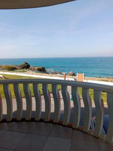 a bench on a balcony looking at the ocean at Apartamento Oceano in Barreiros
