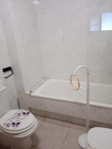a bathroom with a tub and a toilet and a bath tub at Apartamento Oceano in Barreiros