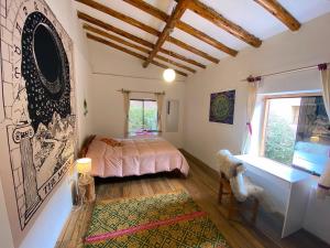 a bedroom with a bed and a desk and a window at Sonqo Andino Hospedaje Medicina in Pisac