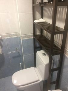 a bathroom with a white toilet and a wooden shelf at Zerka Ayuntamiento in Valencia +6 photos