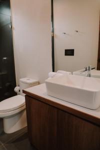 a bathroom with a white sink and a toilet at Lahos Apartament B in Panajachel