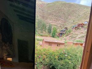 a view of a mountain from a bedroom window at Sonqo Andino Hospedaje Medicina in Pisac