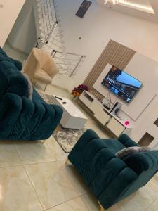 - un salon avec un canapé et une télévision dans l'établissement Jilles apartments -4bedroomduplex24hrlight&security, à Lekki