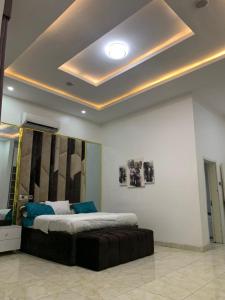 1 dormitorio con 1 cama grande con almohadas azules en Jilles apartments -4bedroomduplex24hrlight&security, en Lekki