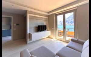 Una sala de estar con un sofá y un televisor. en BRINA apt - Argegno Lake Como, en Argegno