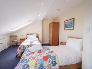 a bedroom with a bed with a quilt on it at Oak Bank in Windermere