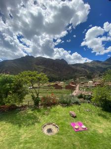 a yard with pink picnic tables in the grass at Sonqo Andino Hospedaje Medicina in Pisac