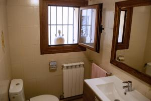 uma casa de banho com um WC, um lavatório e uma janela em Casa Barranquero em Riglos