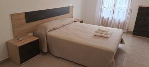 sypialnia z dużym łóżkiem z dwoma ręcznikami w obiekcie Maravilloso piso de dos dormitorios en Huéscar w mieście Huéscar