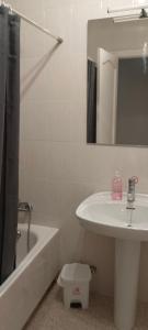 Maravilloso piso de dos dormitorios en Huéscar في هويسكار: حمام مع حوض وحوض استحمام ومرحاض