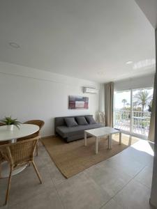 ein Wohnzimmer mit Sofa und Tisch in der Unterkunft Apartamento 2 habitaciones frontal al mar 2 in Torre del Mar