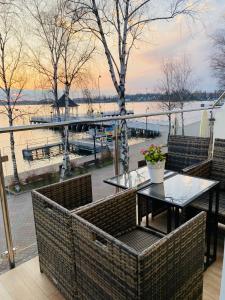 uma varanda com mesa e cadeiras e vista para a água em Apartament MoLoo III em Ostróda