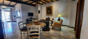 een woonkamer met een tafel, stoelen en een bank bij Apartamento Moctezuma in Ronda