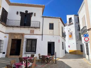 een steegje met tafels en stoelen voor een gebouw bij Apartamento Moctezuma in Ronda