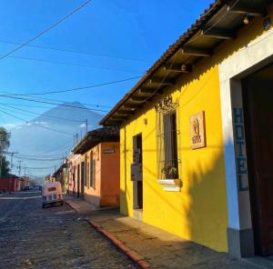 a yellow building on the side of a street at Anexo By Hotel Maya Ik' in Antigua Guatemala