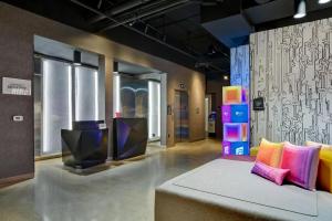 a room with a couch and colorful pillows at Aloft Secaucus Meadowlands in Secaucus