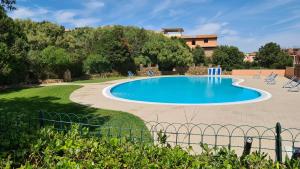 a swimming pool in a yard with chairs around it at Appartamento- La Casa del Mirto- Porto Rotondo in Porto Rotondo